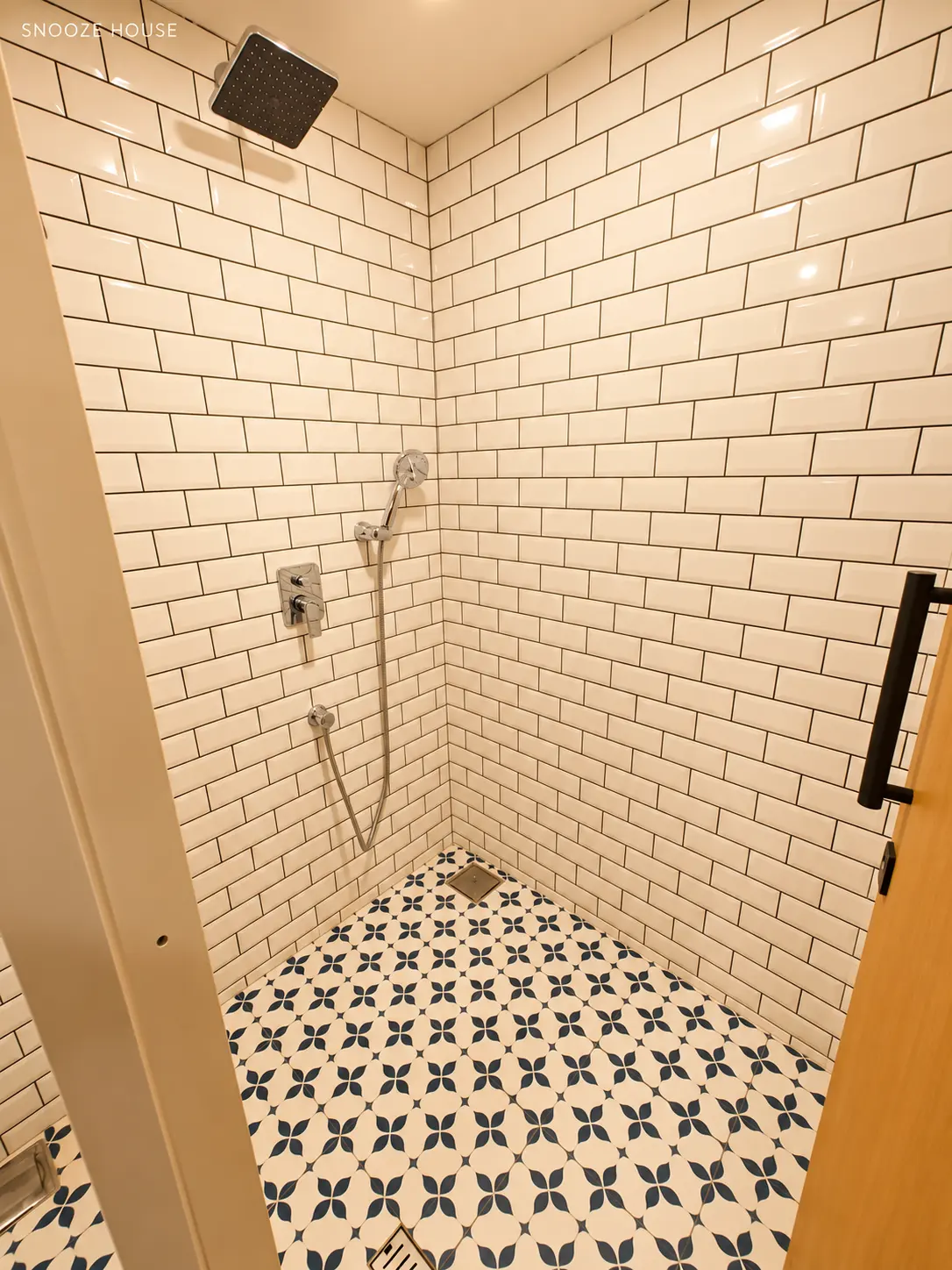 Shower room with white metro tiles, a rain shower and patterned floor tiles